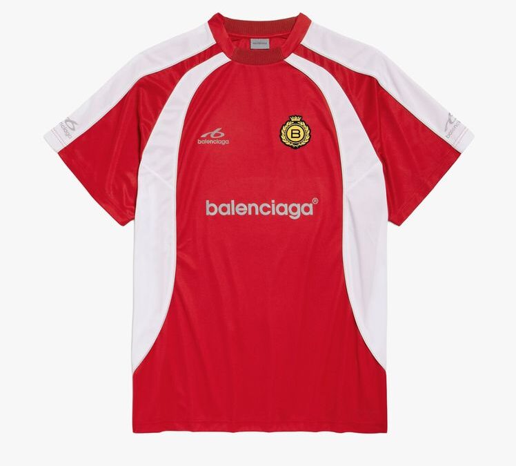 Red soccer jersey with white side panels and Balenciaga branding on the chest, featuring a crest badge on the left.