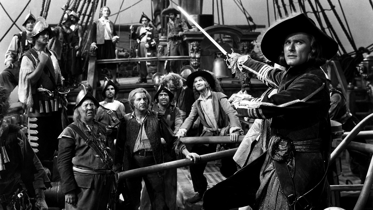 Pirate on a ship deck with a drawn sword, addressing a crew of sailors around him.