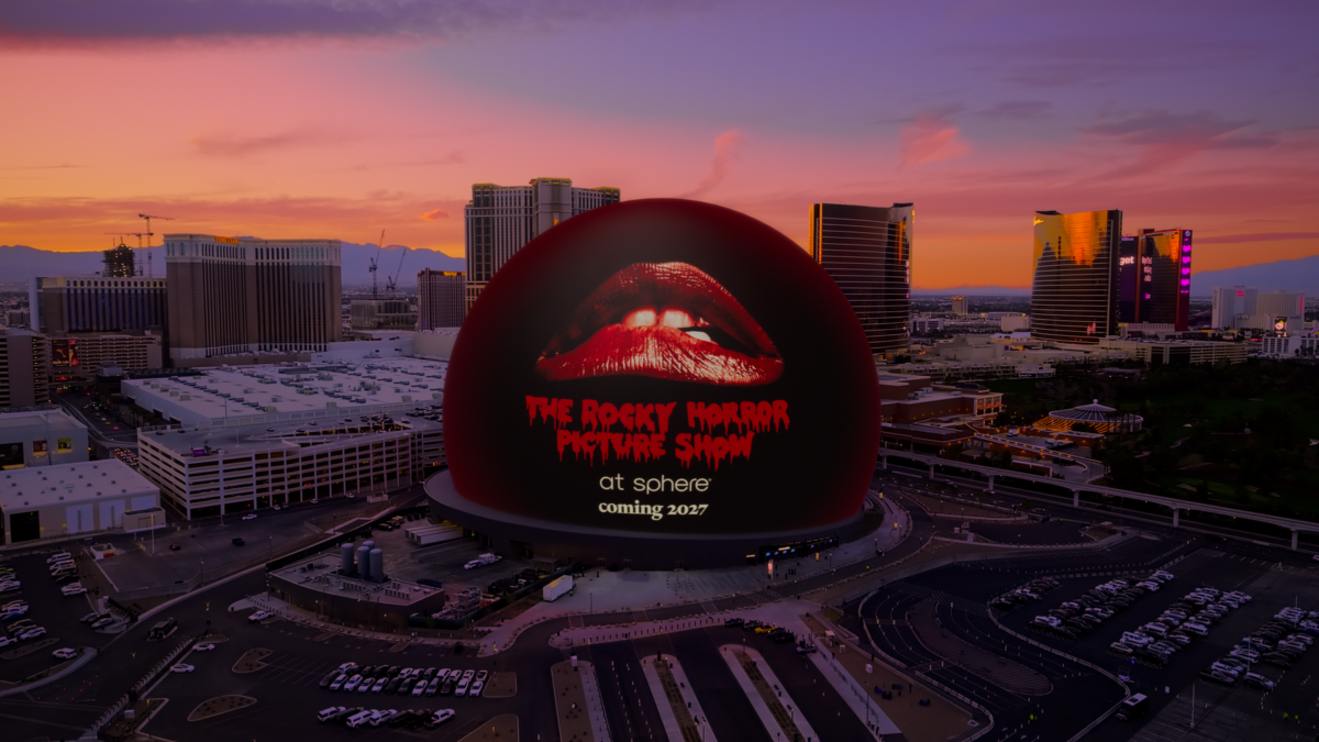 Aerial view of Las Vegas with a giant red sphere billboard featuring lips and text for The Rocky Horror Picture Show, coming 2027 at Sphere.