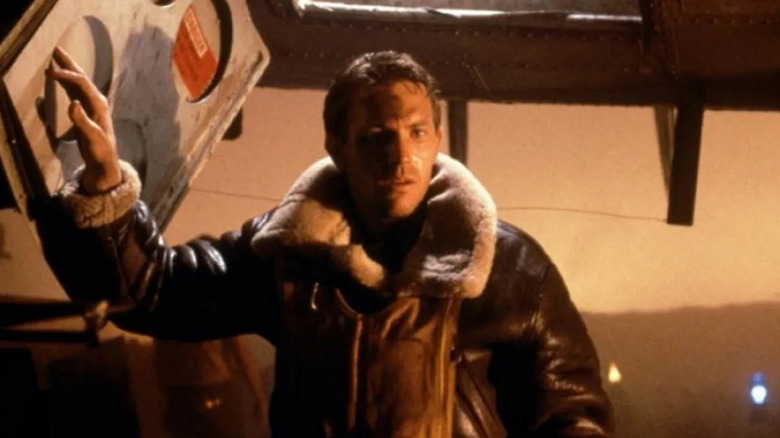 Kevin Costner as Captain stands under a plane in Amazing Stories