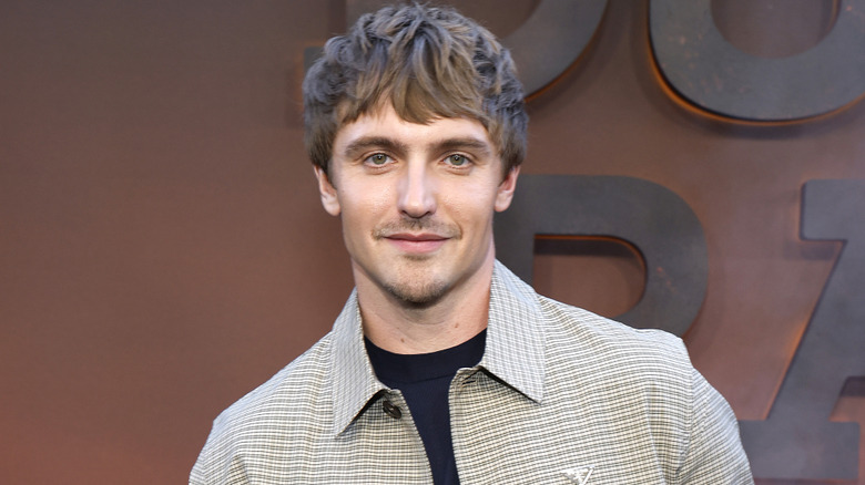 Hart Denton in a gray collared shirt standing in front of a Dutton Ranch sign
