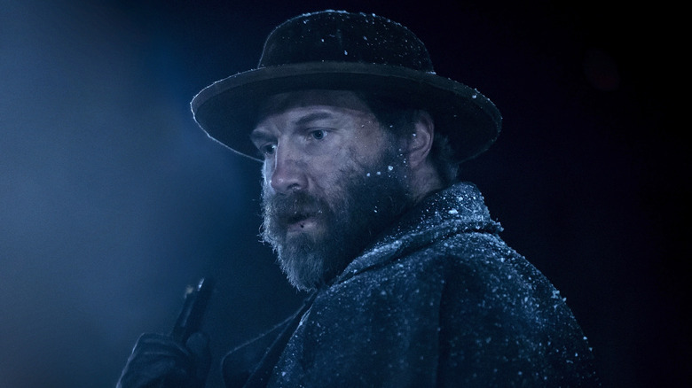 Virgil Cutter wearing a coat and hat with snowflakes on him in American Primeval