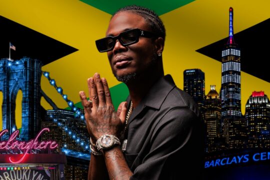 Stylish man with sunglasses and jewelry prays with folded hands in front of a neon New York City skyline and Jamaican flag backdrop