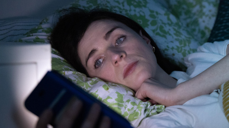 &Aacute;ine checking her phone in bed