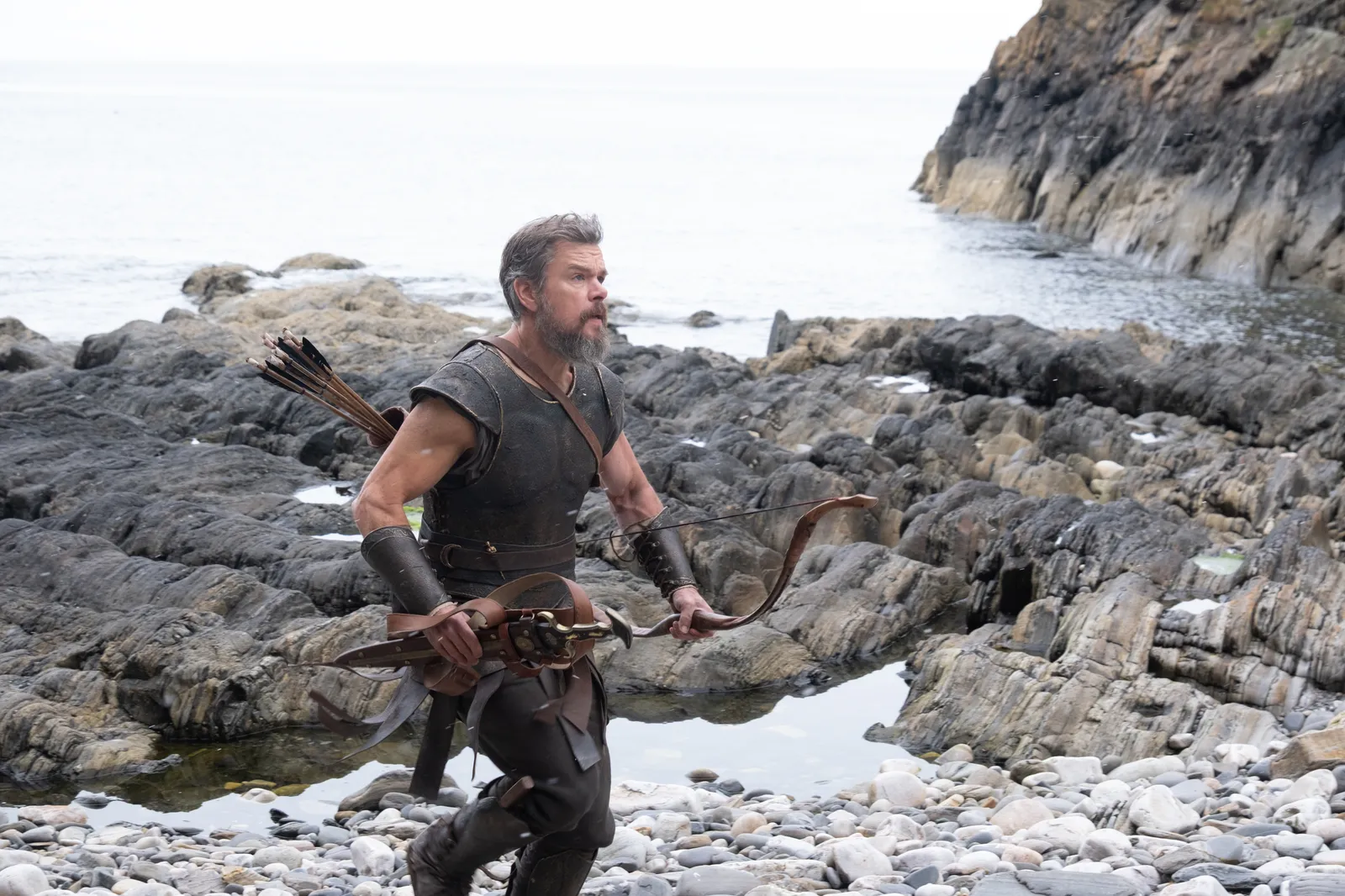 Image may contain Matt Damon Rock Adult Person Clothing Costume Weapon and Sword