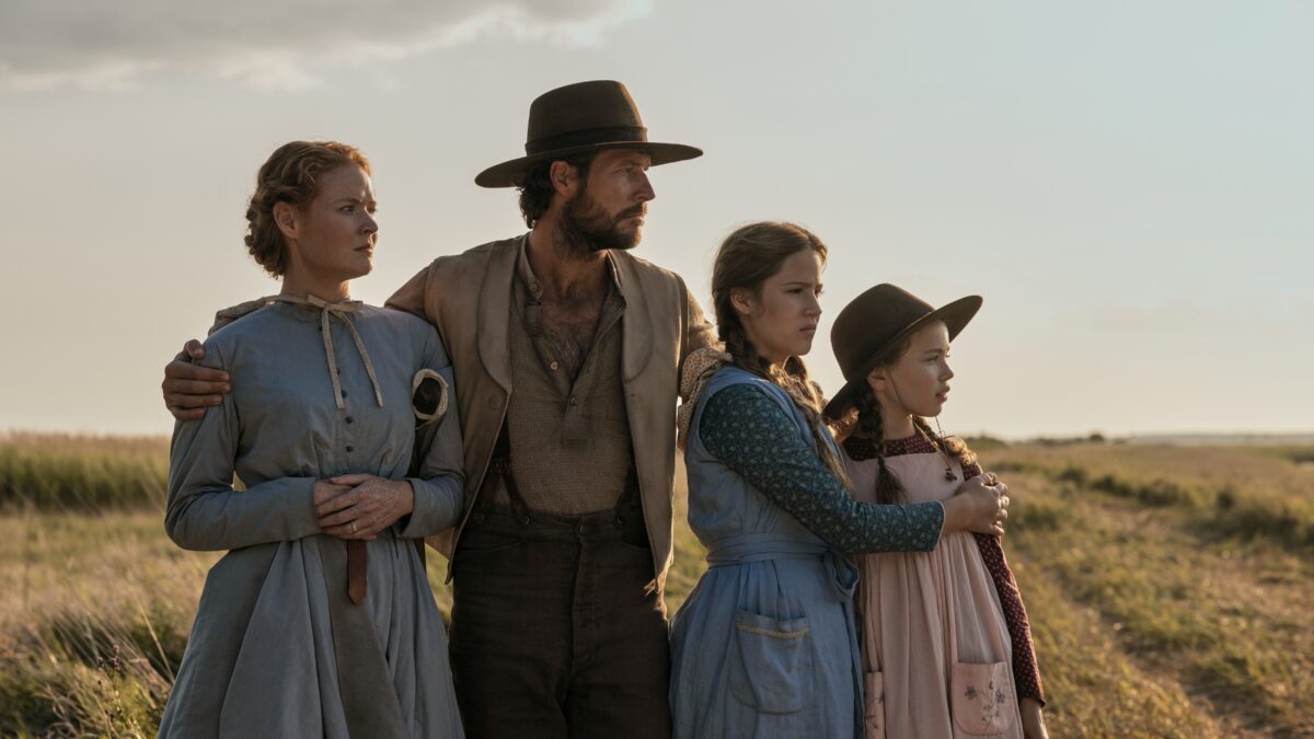 "A family stands together and looks off to the distance. "