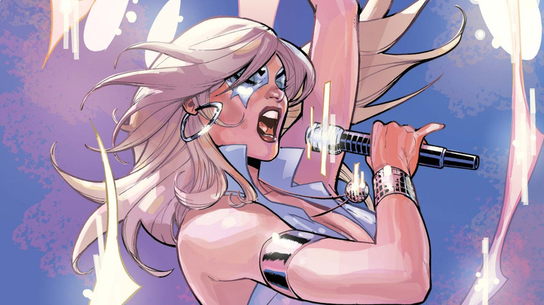 Dazzler belts out a song on a stage.