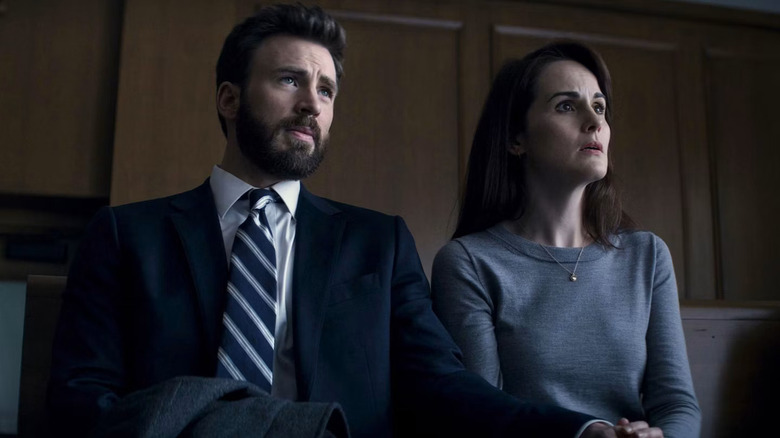 Chris Evans as Andy Barber and Michelle Dockery as Laurie Barber sitting next to each other in Defending Jacob.