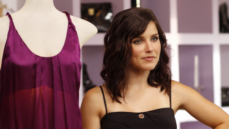 Sophia Bush as Brooke Davis standing next to a dummy bearing a purple dress in "One Tree Hill."