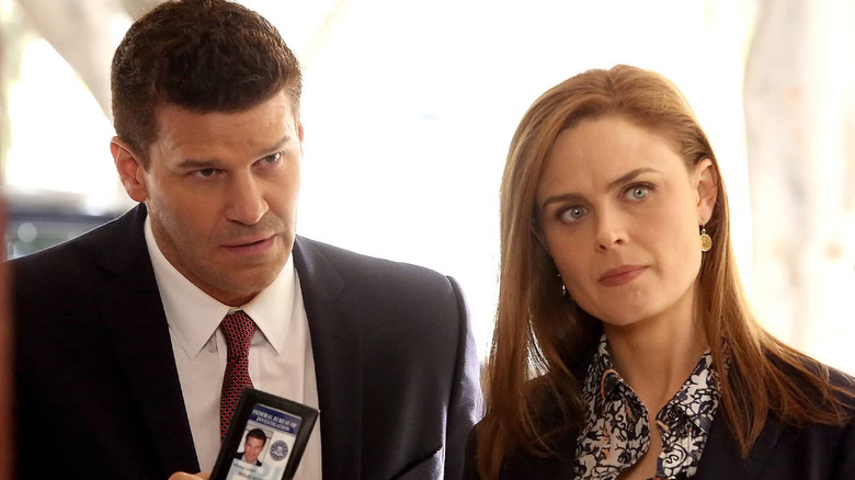 Seeley Booth showing his badge to someone while standing next to Dr. Temperance "Bones" Brennan
