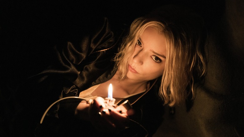 Lucky laying in the dark and holding up a lit lighter