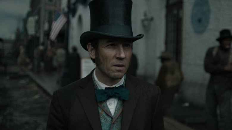 Tobias Menzies as Edwin Stanton, walking through the street in Manhunt.