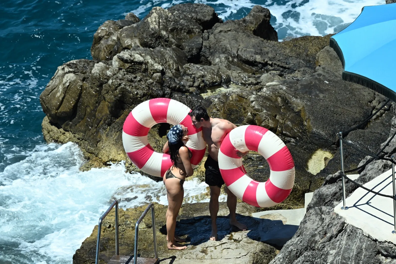 Image may contain Callum Turner Rock Clothing Swimwear Face Head Person Photography Portrait Shorts and Water