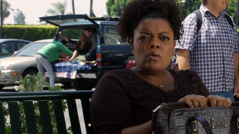 Shirley sits on a bench as Abed delivers a baby behind her in "Community" (2009)