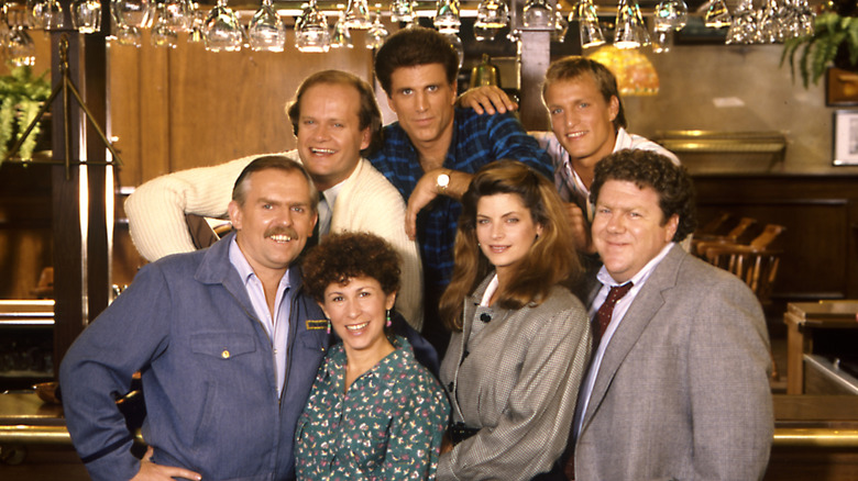 the cast of "Cheers" (1982) pose for a photo on set