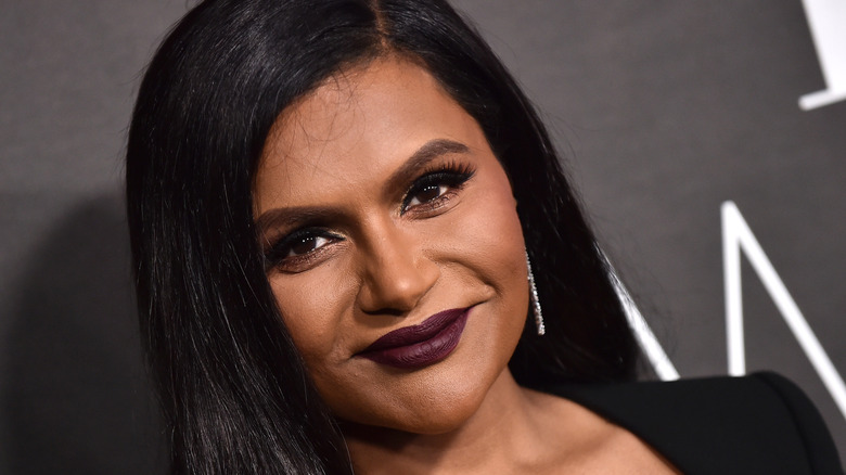 Mindy Kaling in a black pantsuit and deep purple lipstick at the ELLE Women in Hollywood event on October 17, 2022 in Los Angeles, CA
