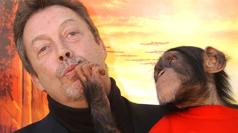 Tim Curry and a chimpanzee at the premiere of "The Wild Thornberrys Movie"