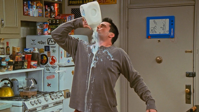 Matt LeBlanc as Joey Tribbiani chugging milk as it spills everywhere in his apartment in Friends