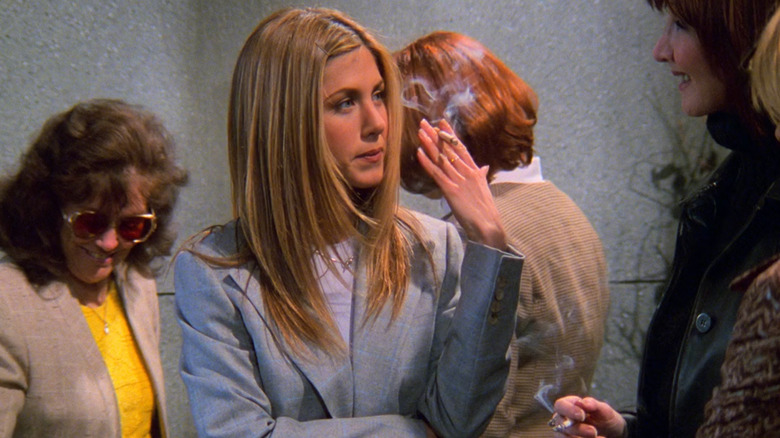 Jennifer Aniston as Rachel Green pretending to smoke a cigarette next to her boss, Joanna Gleason as Kim Clozzi in Friends as