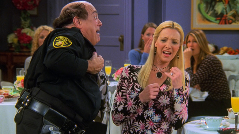 Danny DeVito as Roy AKA Officer Goodbody stripping in front of a grossed out Lisa Kudrow as Phoebe Buffay in Friends