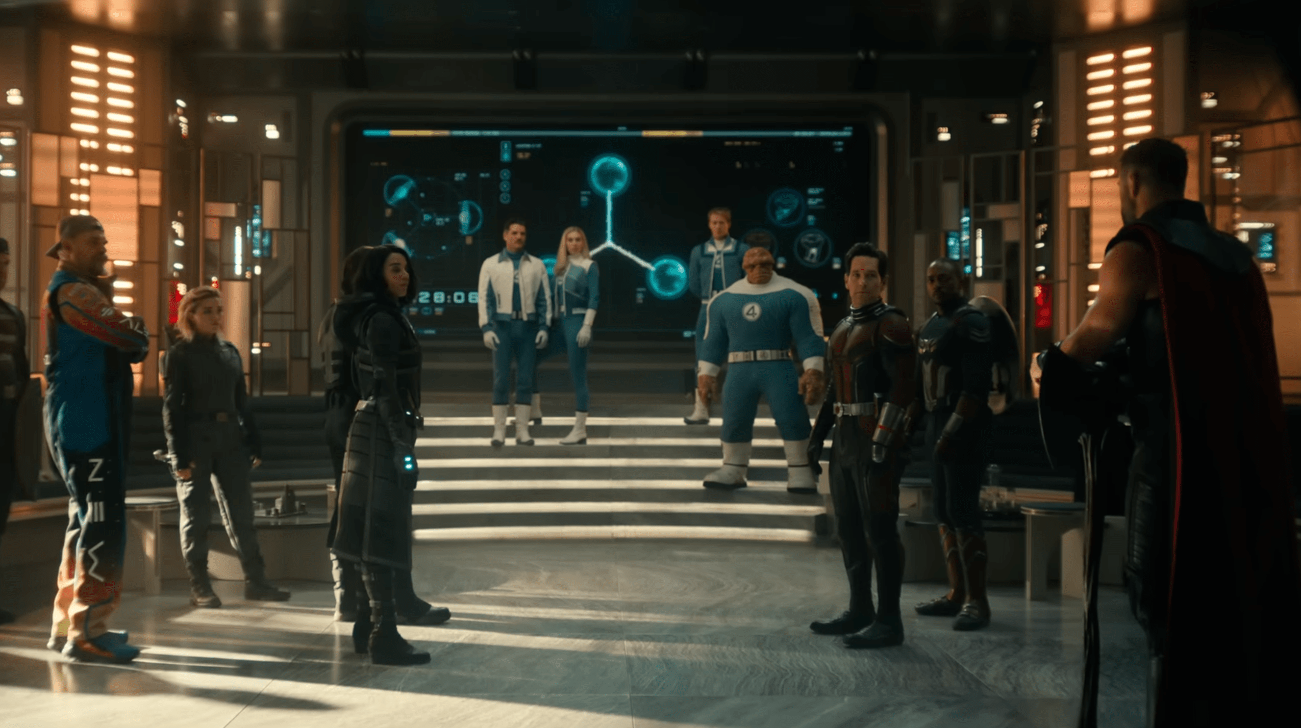 Several costumed figures stand in a futuristic room with glowing wall displays and steps.