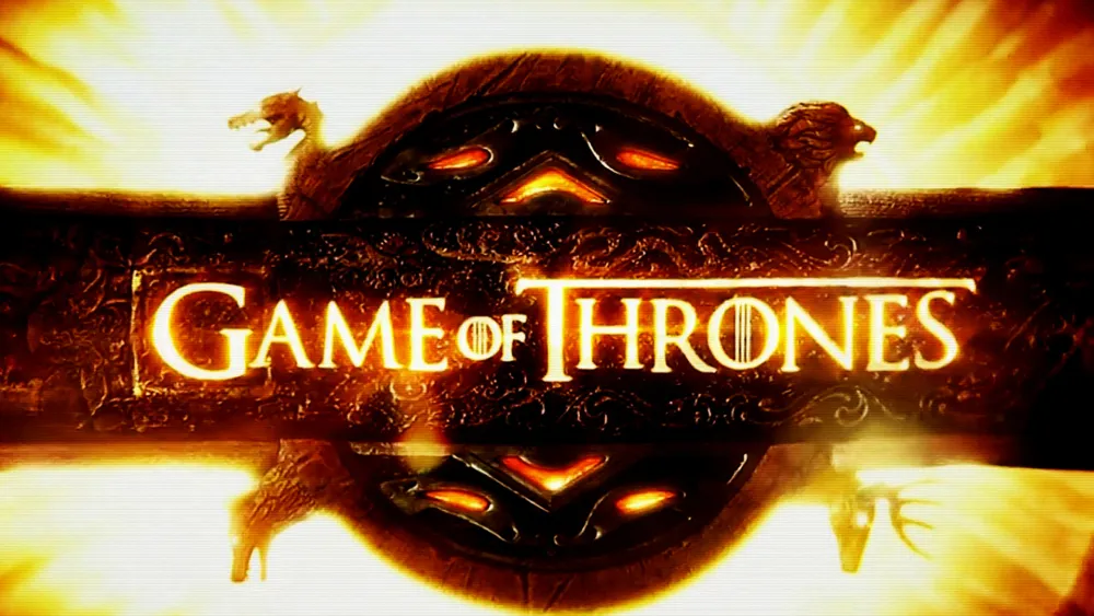 Game of Thrones title glows over an ornate dark emblem against a fiery golden background.