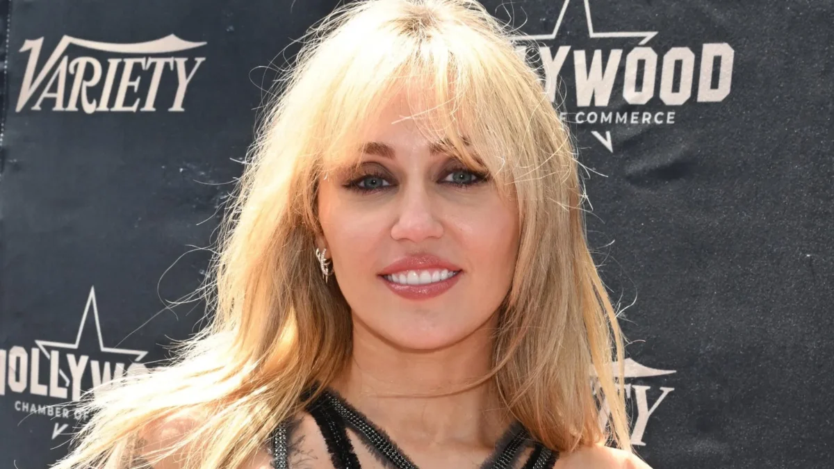 Blonde woman smiling in a black halter outfit before a backdrop with Variety and Hollywood Commerce logos.