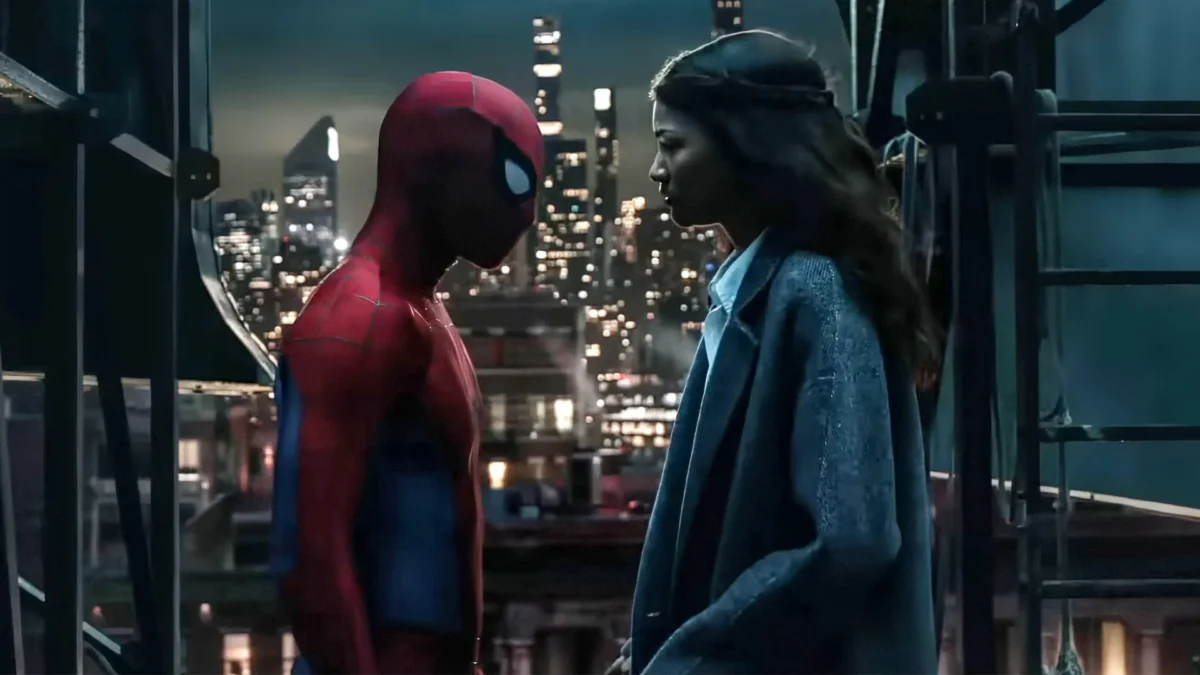 A masked figure in a red-and-blue suit faces another person on a nighttime rooftop with city lights behind them.