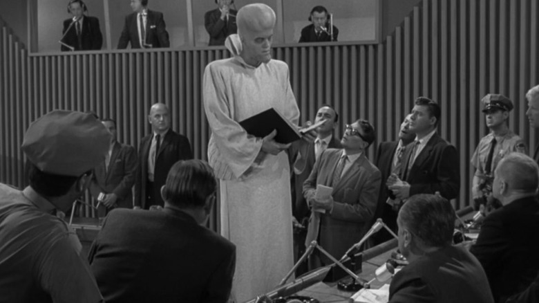 A tall robed alien addresses human delegates on The Twilight Zone episode, "To Serve Man."