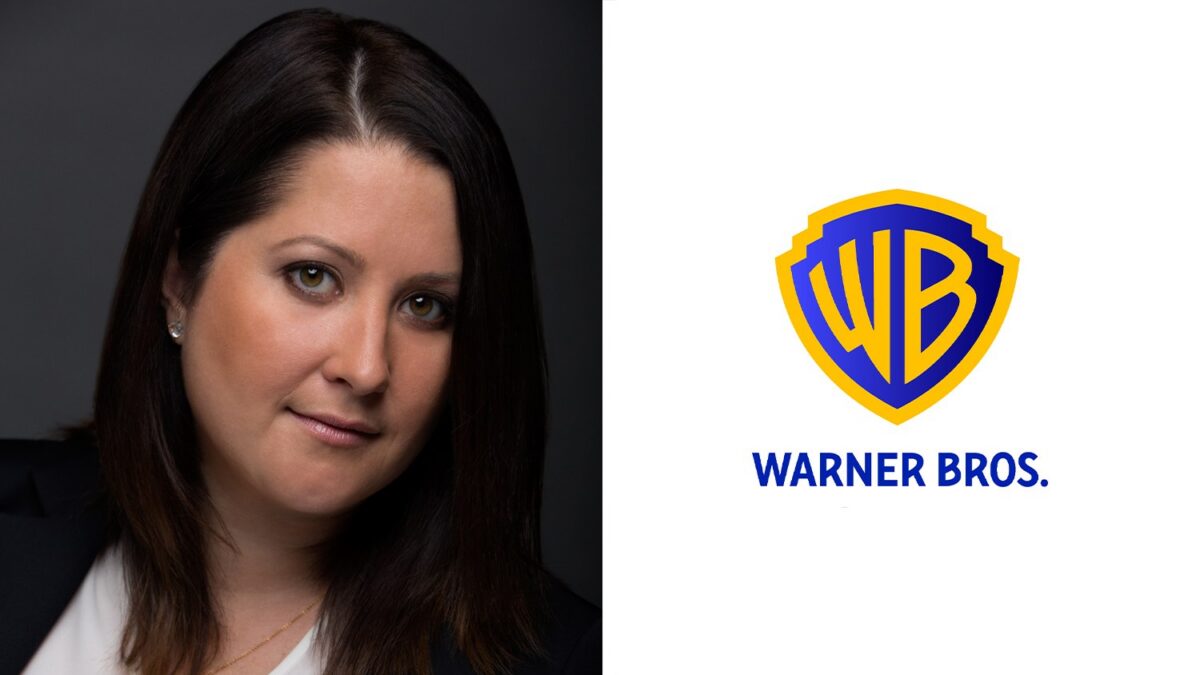 A dark-haired woman in a blazer appears beside the Warner Bros. shield logo on a white background.