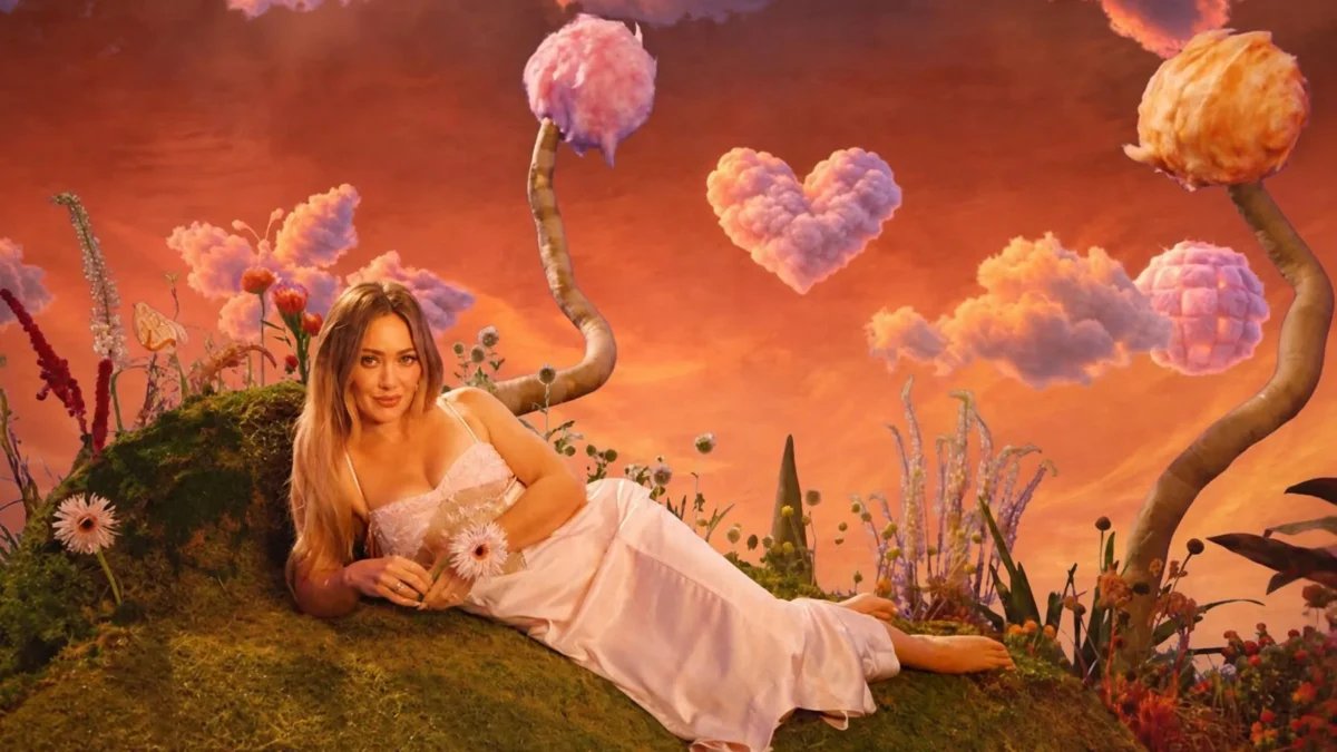 A woman in a white dress reclines in a whimsical garden under orange skies and heart-shaped clouds.