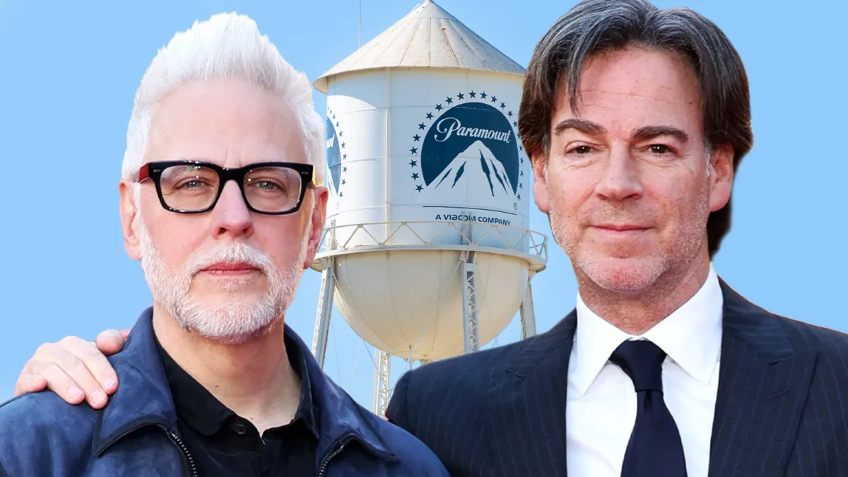 Two men stand in front of a Paramount-branded water tower against a blue sky.