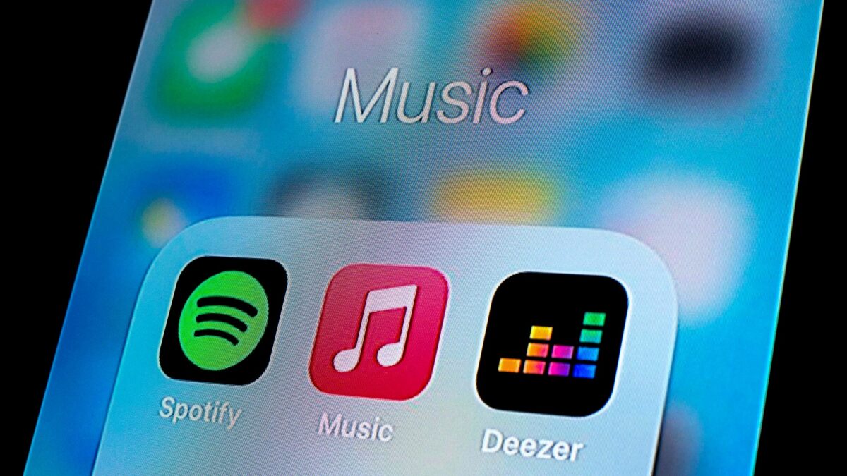 In this photo illustration, a Spotify app, Apple Music app and Deezer app are seen displayed on a smartphone.