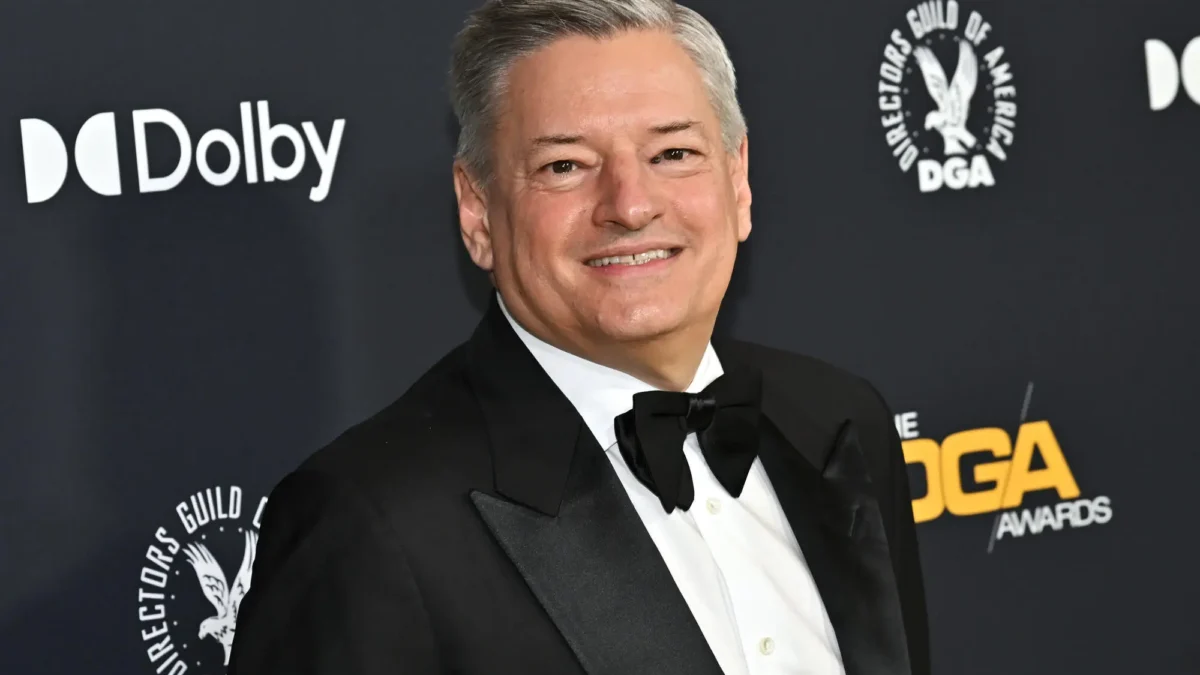 Smiling gray-haired man in a black tuxedo stands before a backdrop with Dolby and DGA Awards logos.