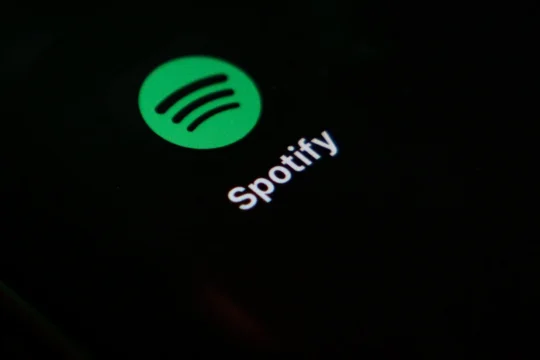 Spotify logo and wordmark glowing on a dark screen.