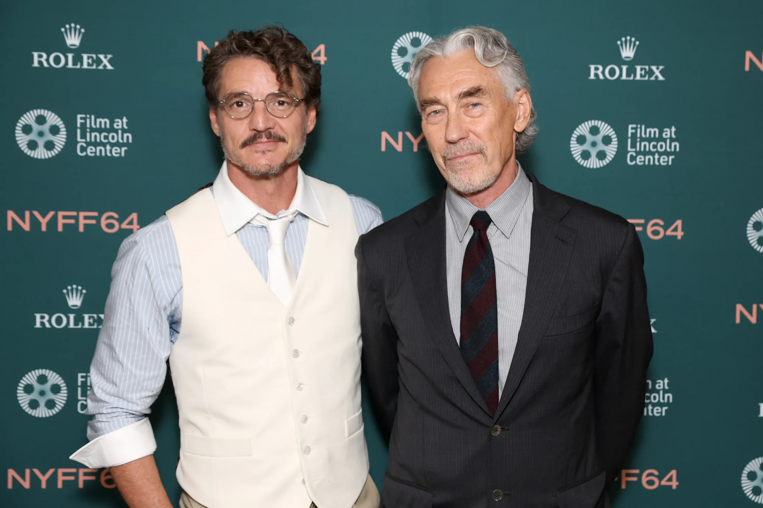 Two men in dress clothes pose before a teal backdrop with Rolex and Film at Lincoln Center logos.